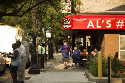 Al's Italian Beef restaurant sign and customers seated on outside patio in University Village