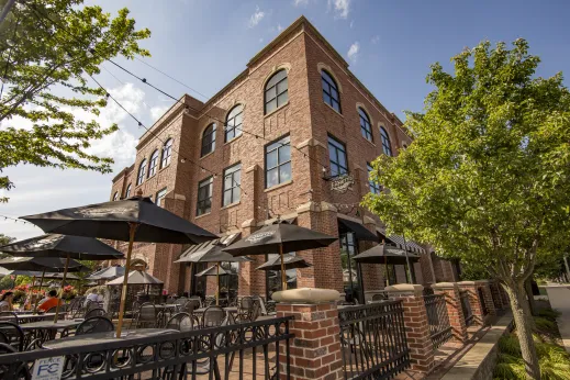 outdoor patio with fence and black umbrellas in front of brick building in Palatine, Illinois