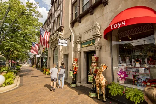 family walking past children store with giraffe in front in Highland Park, IL