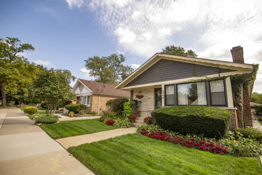 perfectly manicured front lawn of grass and flowers in front of single family house in Washington Heights Chicago