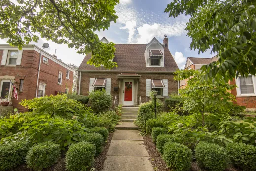 single family house with light post, red front door and green bushes in Auburn Gresham Chicago