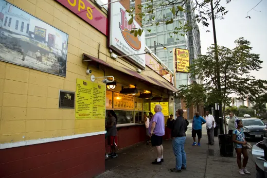 Jim's Original restaurant window sign and customers lined up in University Village