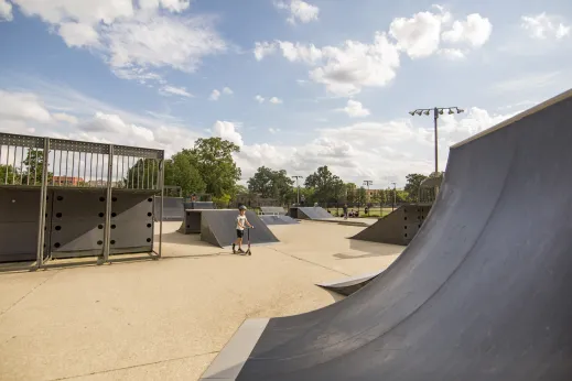 kid on scooter in skate park with ramps in Highland Park