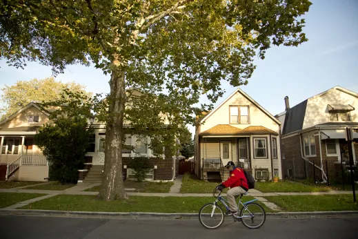 Man riding bike in front of apartment buildings in Kilbourn Park Chicago