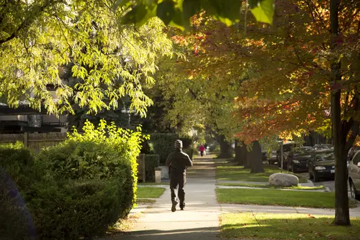 Man walking on neighborhood sidewalk by apartments in Old Irving Park Chicago