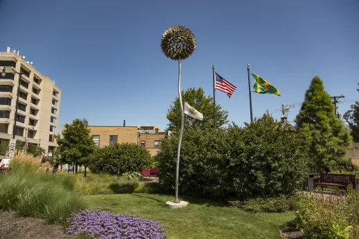 monument flags near building and surrounded by flowers in Skokie IL