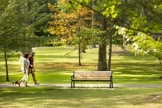 people walking dog in public park in Highland Park