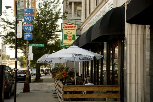 Pizza restaurant sign and outdoor patio seating on N Aberdeen St and N Ogden Ave in River West Chicago