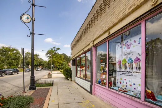 view from sidewalk of pink storefront of bakery along commercial street in Washington Heights Chicago