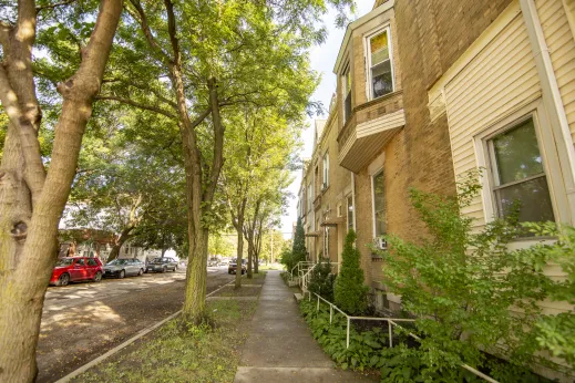 cars parked on street in front of apartment buildings along the sidewalk in Chicago Lawn