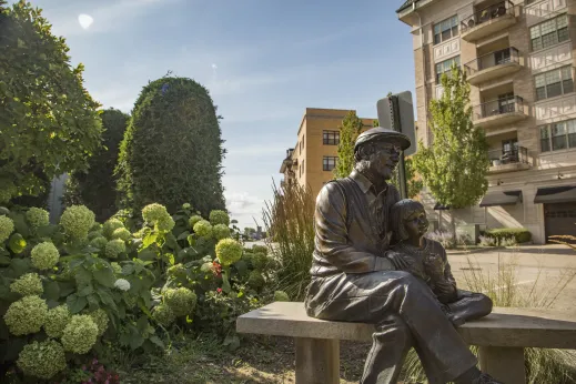 firefighter statue surrounded by flowers and shrubs in Palatine, Illinois