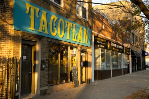 storefront of tacotlan with green awning with sunlight in Hermosa Chicago