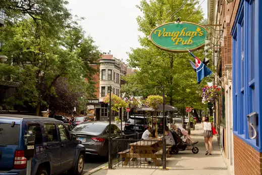 Vaughans Pub sign and patrons seated on outdoor patio in Lakeview Chicago