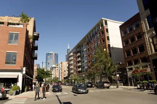 W Madison St restaurants and businesses on street with traffic in the West Loop