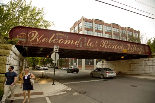 Welcome to Roscoe Village painted sign on viaduct under Metra railroad tracks in Roscoe Village