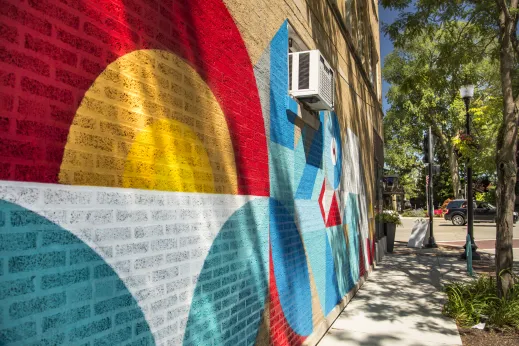 exterior brick of apartment building painted with mural in Skokie Illinois.