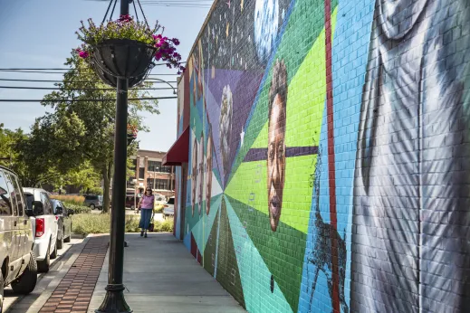 woman walking next to mural on brick building in Skokie IL