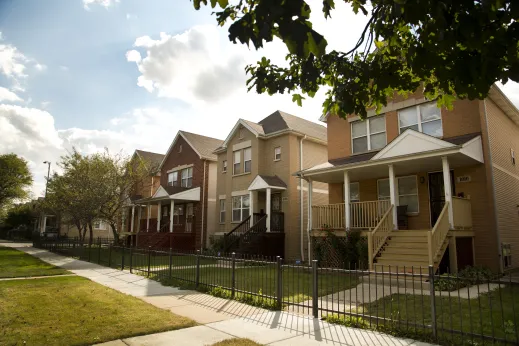 Apartments and single family homes and front lawns on neighborhood street in Austin Chicago