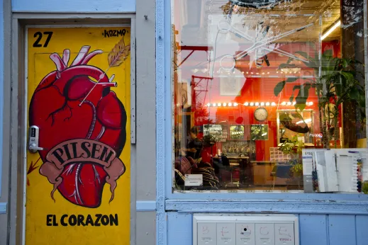 Art mural on apartment building door and barber shop window in Pilsen Chicago