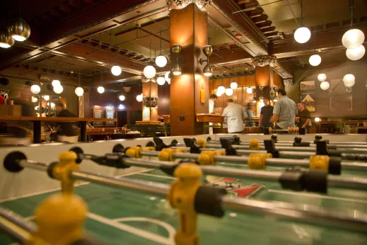 Bar patrons at Chicago Athletic Hotel foosball table in the Loop
