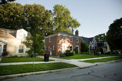 Brick single family home and front lawn with sidewalk in Edgebrook Chicago