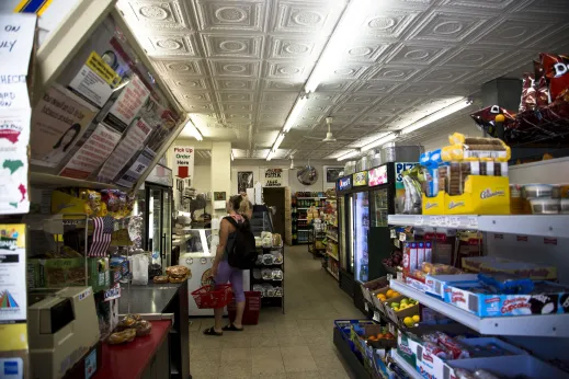 Convenience store customer browsing under pressed tin ceiling in Ukrainian Village Chicago