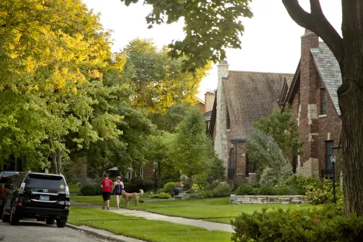 Couple walking dog by single family homes in Sauganash neighborhood