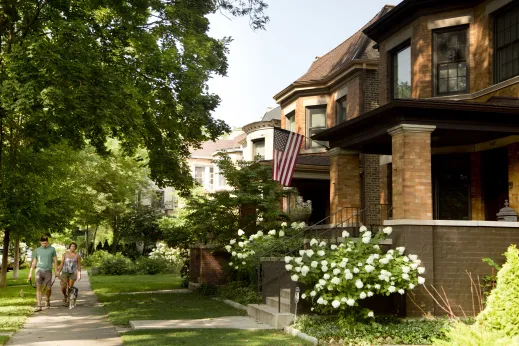 Couple walking with dog in front of historic brick homes in Lakewood Balmoral