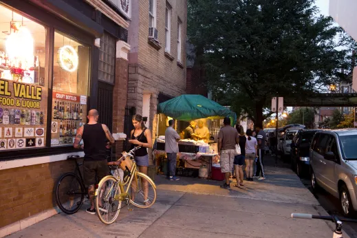 Customers with bicycles pass street vendors parked in Pilsen Chicago