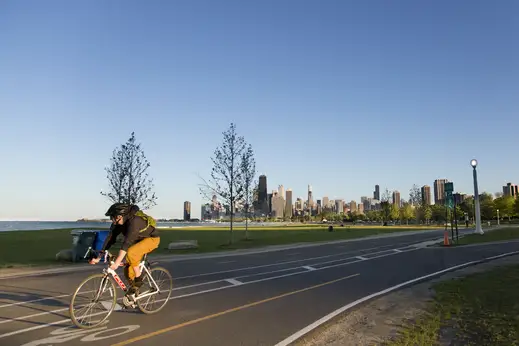 Cyclist on lakefront trail with Chicago skyline in Lincoln Park Chicago