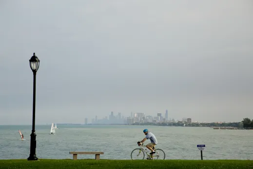 Cyclist riding by Lakefill Chicago skyline background in Evanston