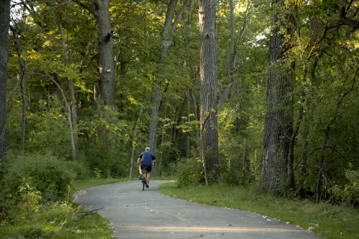 Cyclist riding on bike path in Cook County Forest Preserves in Edgebrook Chicago