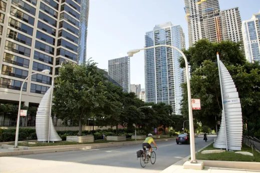 Cyclist riding on street with apartment buildings in Lakeshore East Chicago