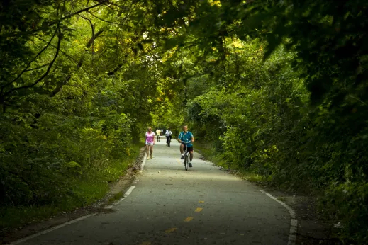 Cyclists and people walking down path near Sauganash neighborhood