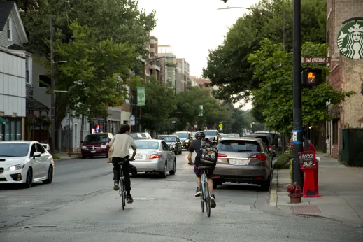 Cyclists riding northbound on street in Hamlin Park Chicago