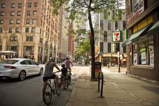 Family waiting on bicycles at traffic light on E Ohio St in Streeterville Chicago