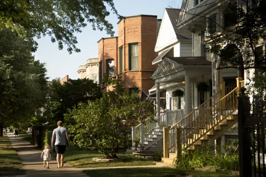 Father and daughter walking by single family homes and apartments in Ravenswood