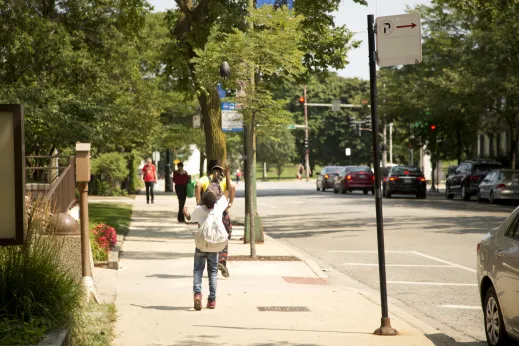 Football playing while waiting at bus stop on Lawrence Avenue by CTA in Margate Park