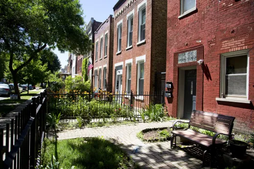 Front yard patio of apartment buildings with paver bricks and bench in Ukrainian Village Chicago