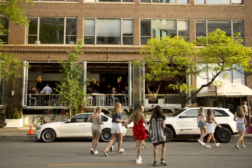 Girls crossing the street with Hampton Social restaurant in background on West Hubbard in River North Chicago