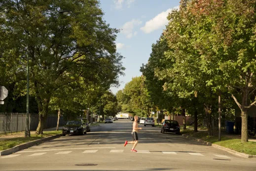 Jogger crossing the road on neighborhood street in Fuller Park Chicago