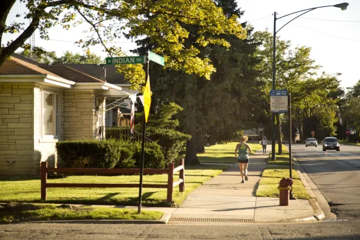 Jogger running on sidewalk by single family homes on W Central Ave in Edgebrook Chicago