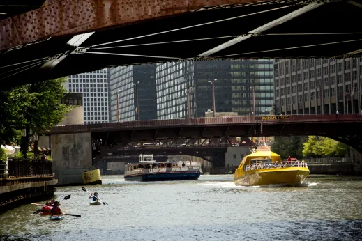 Kayaks sightseeing and boats in Chicago River in the Loop