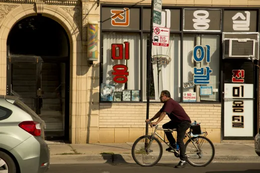 Man rides bike in front of local business on W Lawrence Ave in Mayfair Chicago