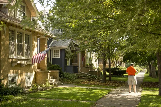 Man standing in front yard of a residential street with single family homes in North Park Chicago