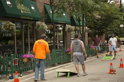 Men playing bags outside Lizzie McNeills Irish Pub in Streeterville Chicago