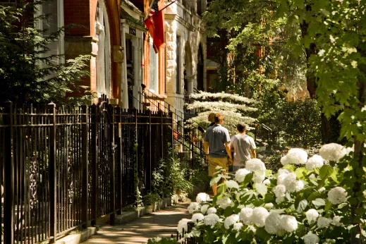 Men walking on sidewalk by apartment front gardens in Ukrainian Village Chicago