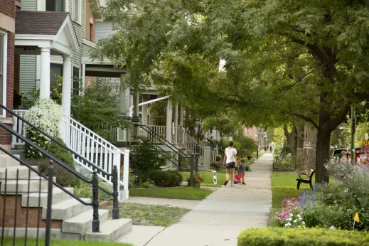 Mother and child walking down sidewalk by front porches and houses in St. Ben's Chicago
