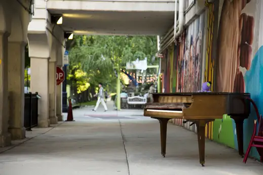 Outdoor piano and art mural on viaduct on N Glenwood Ave in Rogers Park Chicago