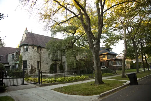Outside of old stone mansion with wrought iron gate and driveway in South Shore Chicago